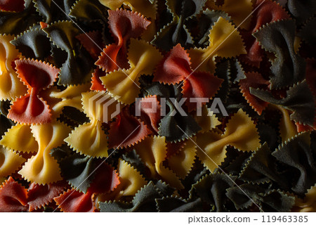 Dry Uncooked Colored Farfalle Pasta and Raw Macaroni on a Textured Background Dry Uncooked Colored Farfalle Pasta and Raw Macaroni on a Textured Background 119463385