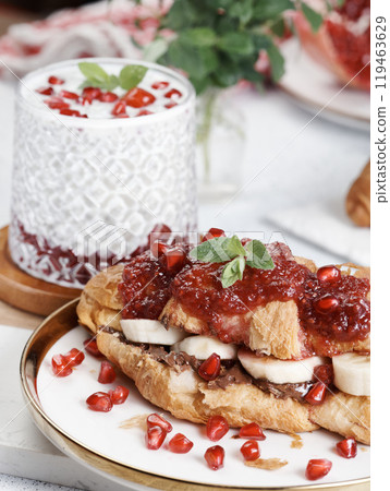 Croissant with chocolate, banana pieces and raspberry jam on a plate Croissant with chocolate, banana pieces and raspberry jam on a plate 119463629