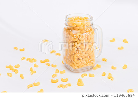 Uncooked Chifferi Rigati Pasta in Glass Jar on White Background 119463684
