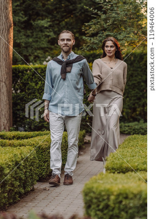 Love, hug and happy with couple in park for romance, bonding and summer vacation. Loving young couple hugging and smiling together on nature background. Beautiful girl with tattooed body outdoor. 119464006