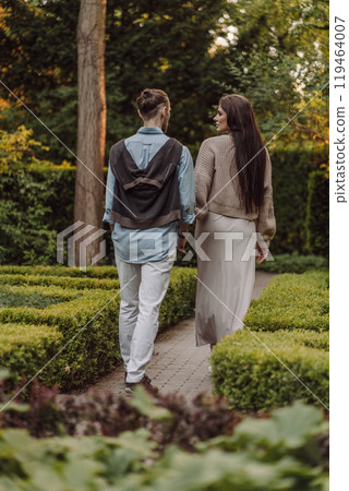 Love, hug and happy with couple in park for romance, bonding and summer vacation. Loving young couple hugging and smiling together on nature background. Beautiful girl with tattooed body outdoor. 119464007