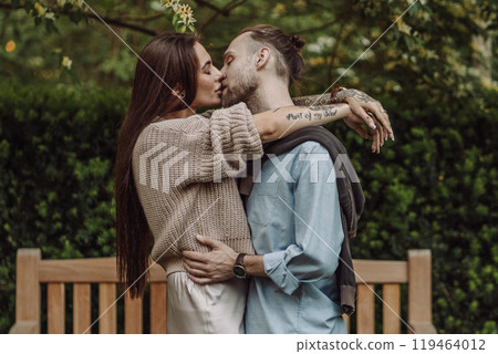 Happy loving couple enjoying their time together in park. Loving couple spending time together. Girl with tattoos. Tattooed woman. Beautiful fashionable couple of lovers on the street. Happy loving couple enjoying their time together in park. Loving couple spending time together. Girl with tattoos. Tattooed woman. Beautiful fashionable couple of lovers on the street. 119464012