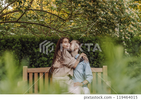 Happy loving couple enjoying their time together in park. Loving couple spending time together. Girl with tattoos. Tattooed woman. Beautiful fashionable couple of lovers on the street. 119464015