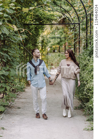 Copy space. overs are laughing. Happy guy and girl. Lovers enjoy each other in the evening park. Happy romantic moments of lovely couple in park during dating. Girl with tattoos. 119464034
