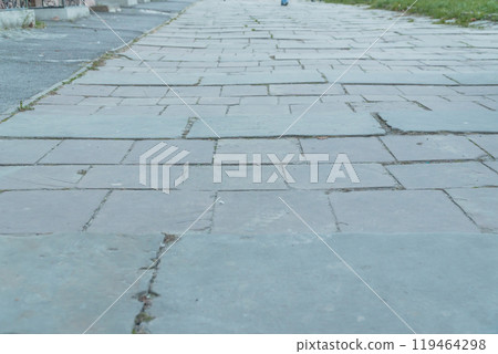 A Serene Perspective of Weathered Paving Stones Along a Sidewalk A Serene Perspective of Weathered Paving Stones Along a Sidewalk 119464298