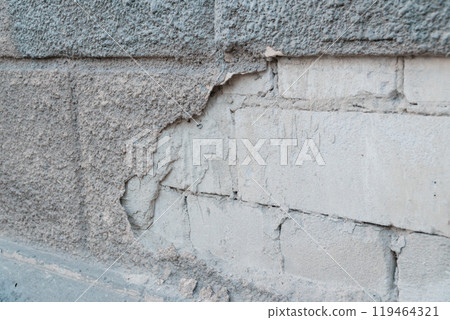 Crumbling Texture of an Aged Concrete Wall with Exposed Bricks and Layered Surfaces 119464321