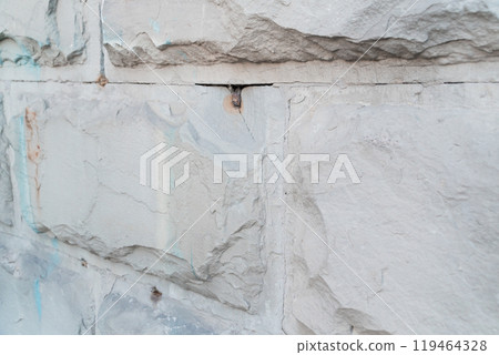 Textured Gray Stone Wall with Visible Cracks and Unique Patterns Textured Gray Stone Wall with Visible Cracks and Unique Patterns 119464328
