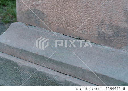 Detailed Texture and Weathering of a Historic Stone Base 119464346
