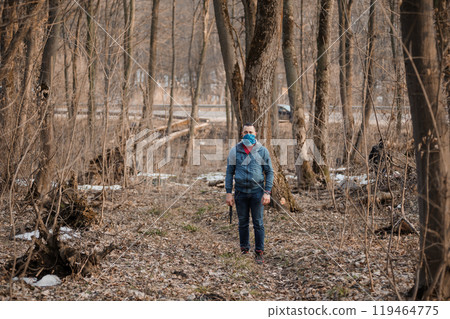 A solitary figure in a tranquil forest setting during early spring 119464775