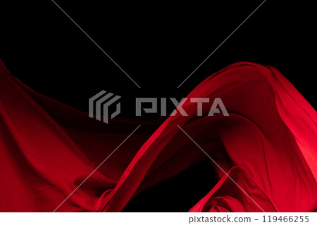 Red Cotton fabric flying in curve shape, Piece of textile Red cotton fabric throw fall in air. Black background isolated, dark shading environment 119466255