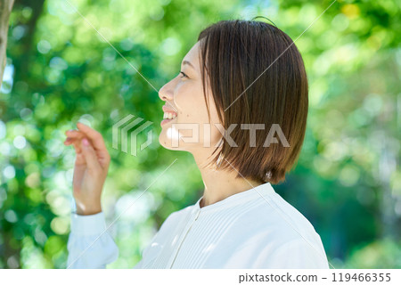 Smiling woman in the greenery on a nice day 119466355