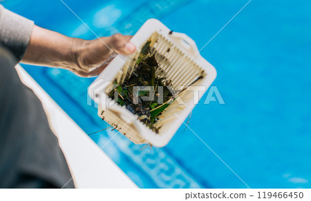 Man cleaning garbage filter basket for swimming pool. trash. Hand holding swimming pool filter basket Man cleaning garbage filter basket for swimming pool. trash. Hand holding swimming pool filter basket 119466450