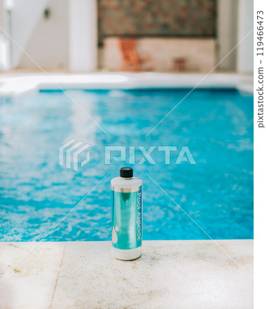 Bottle of algicide for cleaning home pools. Algicide powder for cleaning and purifying swimming pools 119466473