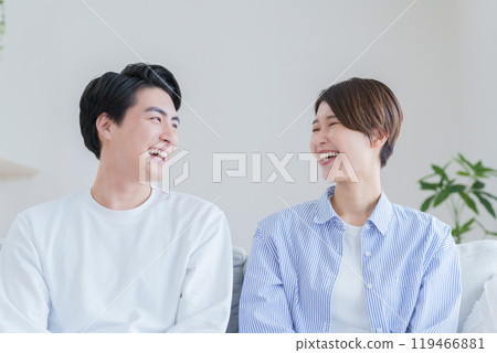 一對 30 多歲的微笑夫婦在客廳裡消磨時光 119466881