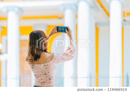 Girl taking photos of the Granada cathedral with cell phone. Young tourist taking photos of a tourist cathedral with cell phone Girl taking photos of the Granada cathedral with cell phone. Young tourist taking photos of a tourist cathedral with cell phone 119466919