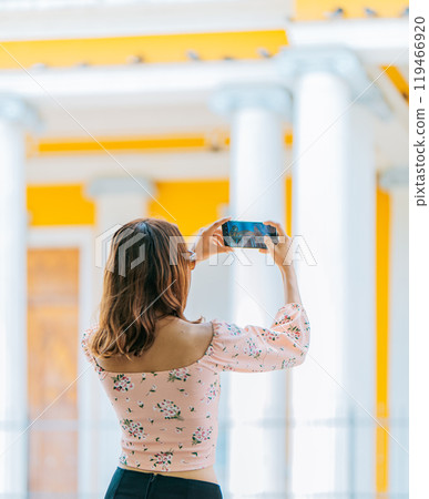 Young tourist taking photos of a tourist cathedral with cell phone. Girl taking photos of the Granada cathedral with cell phone 119466920