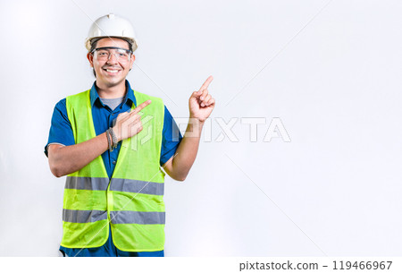 Happy male engineer pointing to side isolated. Smiling male engineer pointing blank space isolated 119466967
