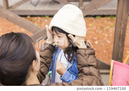 一位母親在露營地為女兒戴上帽子 一位母親在露營地為女兒戴上帽子 119467180