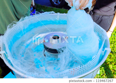 Making blue cotton candy in outdoors by using machine pan Making blue cotton candy in outdoors by using machine pan 119467267