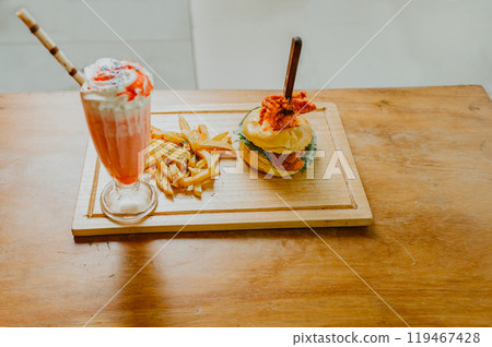 Hamburger with french fries and strawberry milkshake on wooden table isolated Hamburger with french fries and strawberry milkshake on wooden table isolated 119467428