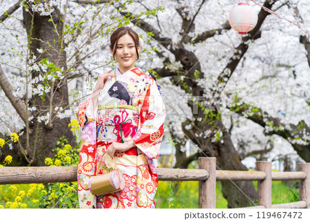 身穿長袖和服的年輕女子，櫻花盛開 119467472