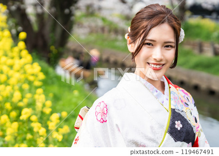 身穿長袖和服的年輕女子，櫻花盛開 119467491