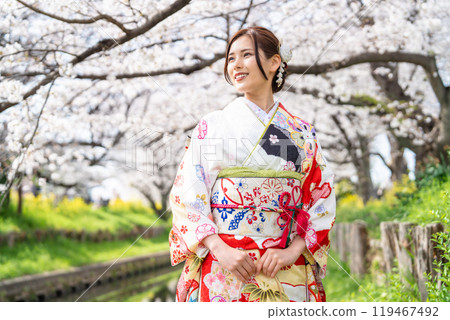 身穿長袖和服的年輕女子,櫻花盛開 身穿長袖和服的年輕女子,櫻花盛開 119467492