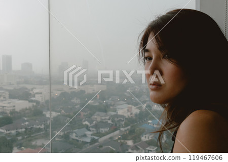 Lonely woman sitting alone looking out thoughtful of life. 119467606