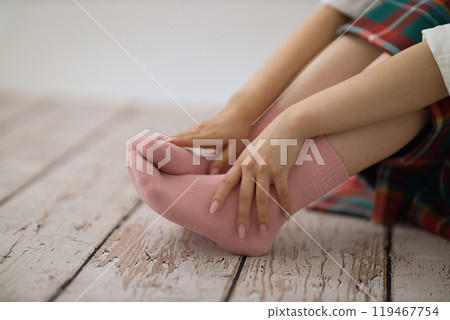 The feet of a young woman putting on socks The feet of a young woman putting on socks 119467754