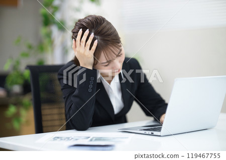 A young businesswoman feeling down at work 119467755