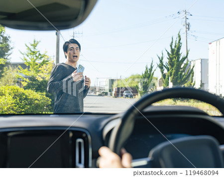 A man walking with a smartphone is nearly hit by a car 119468094