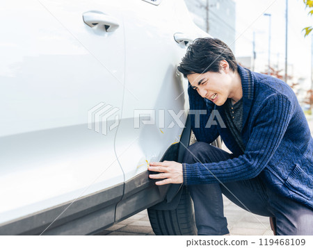 A male driver is depressed after denting the body of his car A male driver is depressed after denting the body of his car 119468109