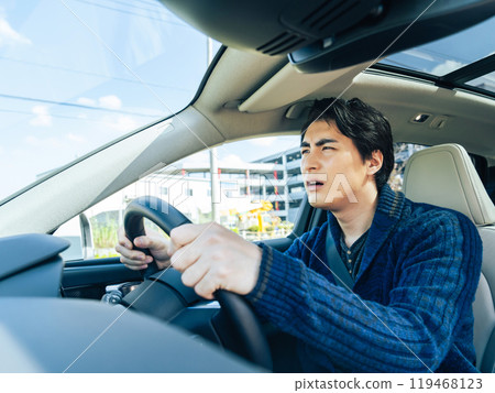 A scene in a car of a male driver driving an automobile with anxiety 119468123
