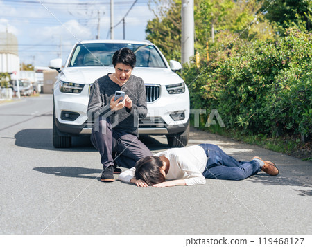 A driver who has caused a traffic accident and hastily reports it on his smartphone A driver who has caused a traffic accident and hastily reports it on his smartphone 119468127