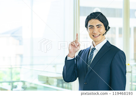 Male business person wearing a headset and making a recommendation in an office building Male business person wearing a headset and making a recommendation in an office building 119468193