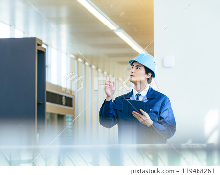 A male worker inspecting a building using a tablet PC A male worker inspecting a building using a tablet PC 119468261