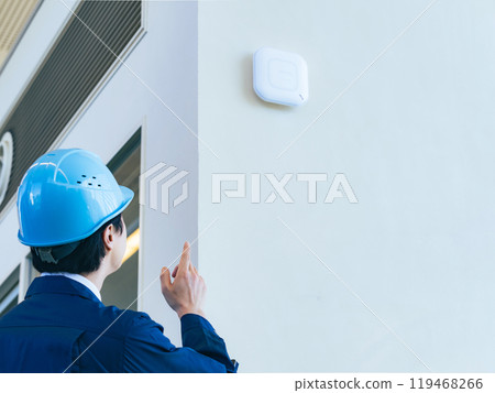 A male worker inspecting equipment inside a building 119468266