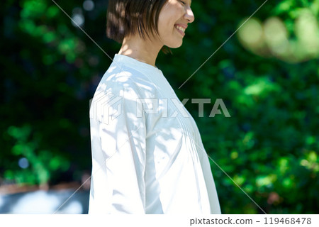 A woman relaxing in the greenery on a sunny day 119468478