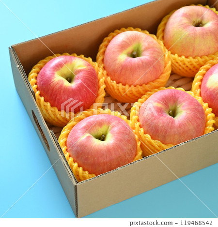beautiful pink apple in the box on blue background beautiful pink apple in the box on blue background 119468542