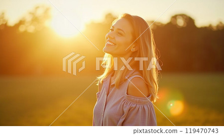 Young woman standing outdoors feeling the sun on her face 119470743