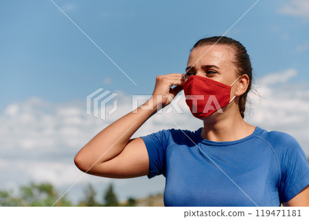 Athlete woman is getting ready to run with a mask on her face Athlete woman is getting ready to run with a mask on her face 119471181