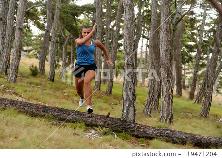 Fearless Woman Conquering Wooden Obstacles in the Dangerous Forest Terrain. 119471204