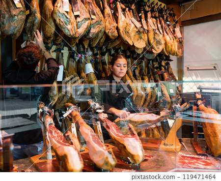 Young woman and man in uniform selling jamon 119471464