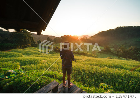 Rural rice field tour, man standing taking pictures on the rice field terrace and morning light 119471473