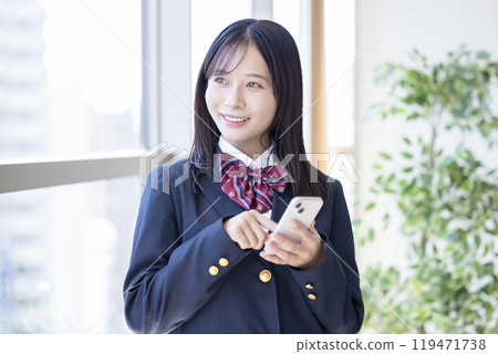 High school girl watching smartphone High school girl watching smartphone 119471738