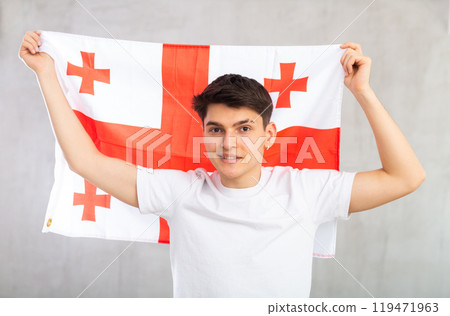 Smiling young guy holding flag of Georgia Smiling young guy holding flag of Georgia 119471963
