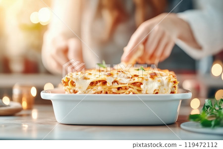 Delicious homemade lasagna served on a white dish, ready to be enjoyed during a cozy meal. 119472112