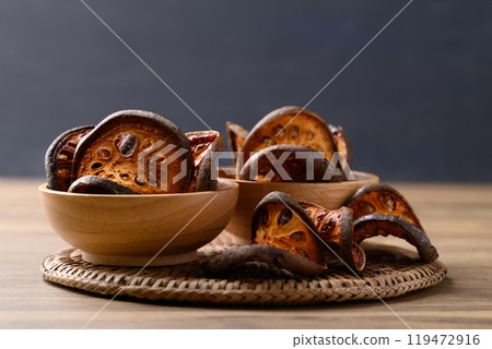 Dried Bael fruit in wooden bowl, Herbal drink ingredient 119472916