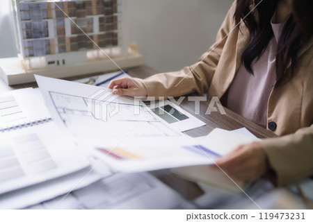 Female architect checking sketch of interior building project and color swatch sample on blueprint Female architect checking sketch of interior building project and color swatch sample on blueprint 119473231
