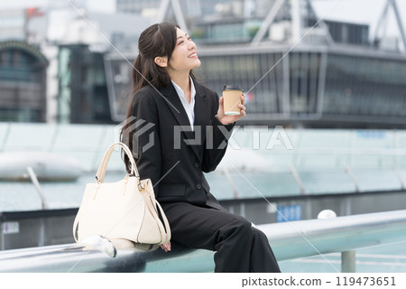 年輕女商人在市中心喝外帶咖啡放鬆 119473651